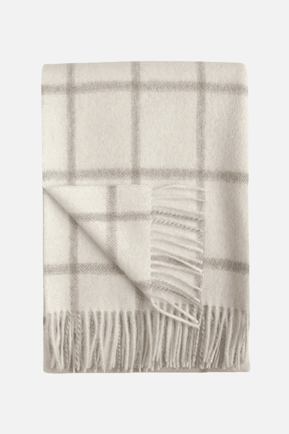 Folded Picton Throw showcasing its light grey check pattern on an off-white base, with fringed detailing for added elegance.