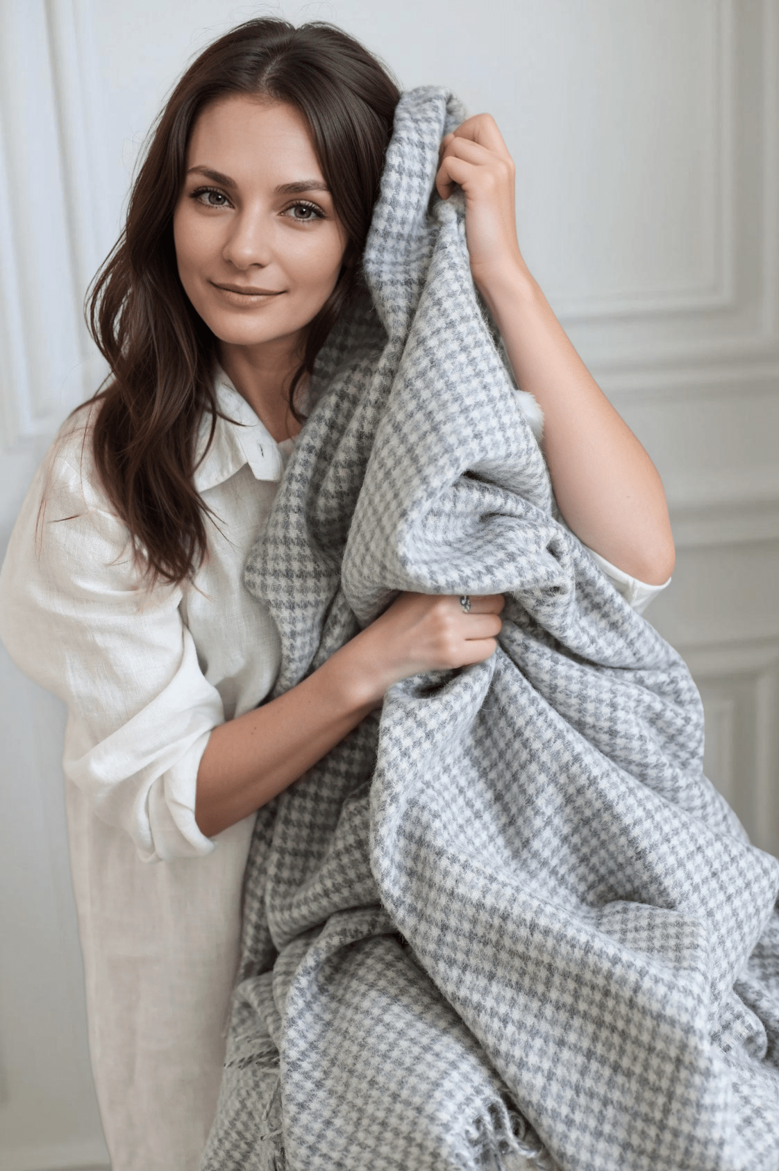 Woman holding the Temagami Alpaca Throw, highlighting its soft texture and sustainable blend of alpaca and wool for cozy, elegant living.
