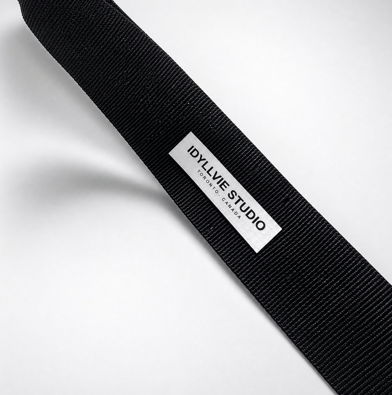Black strap with 'IdyllVie Studio' label on a white background