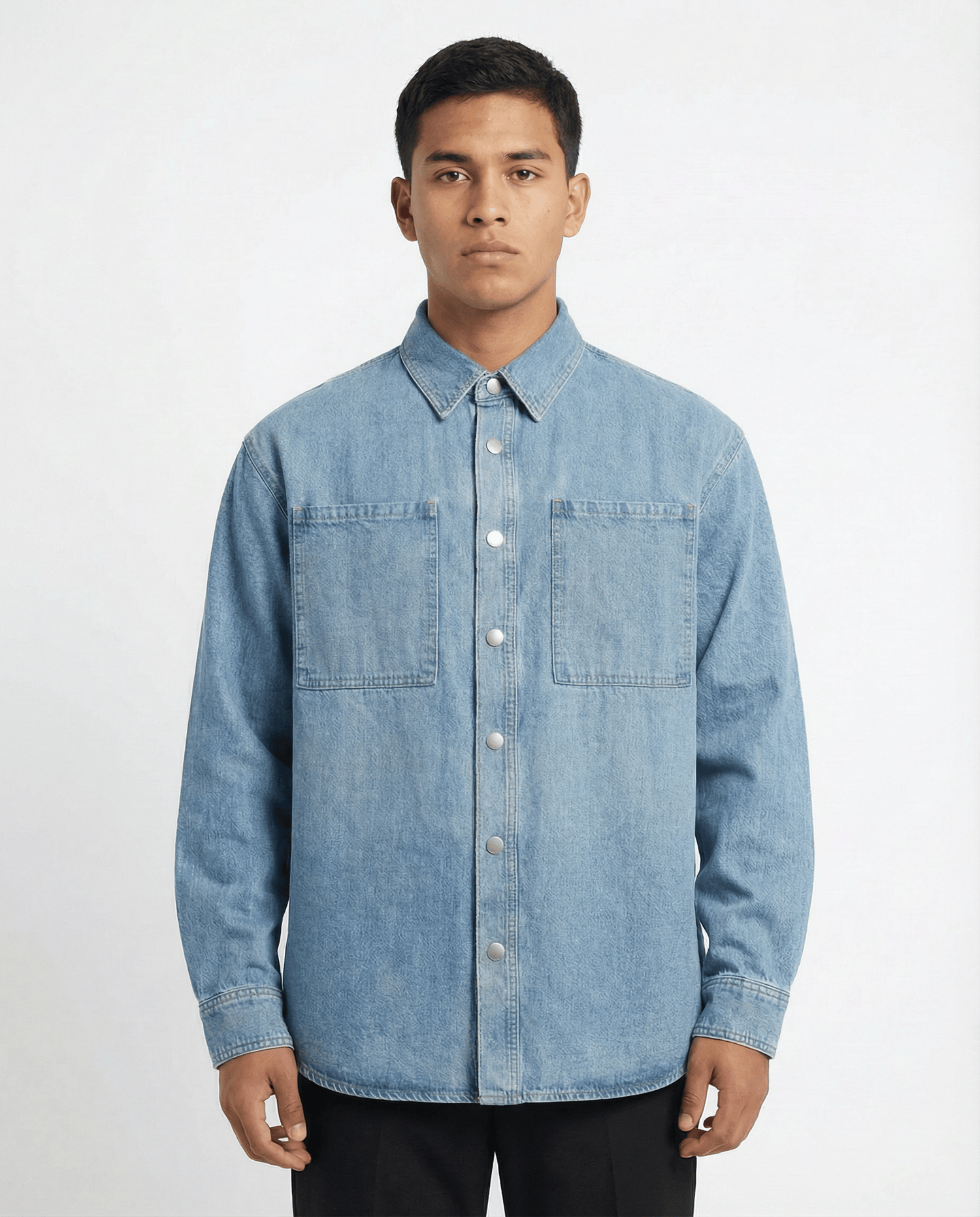 Model wearing light blue denim long sleeve overshirt with black pants and white sneakers