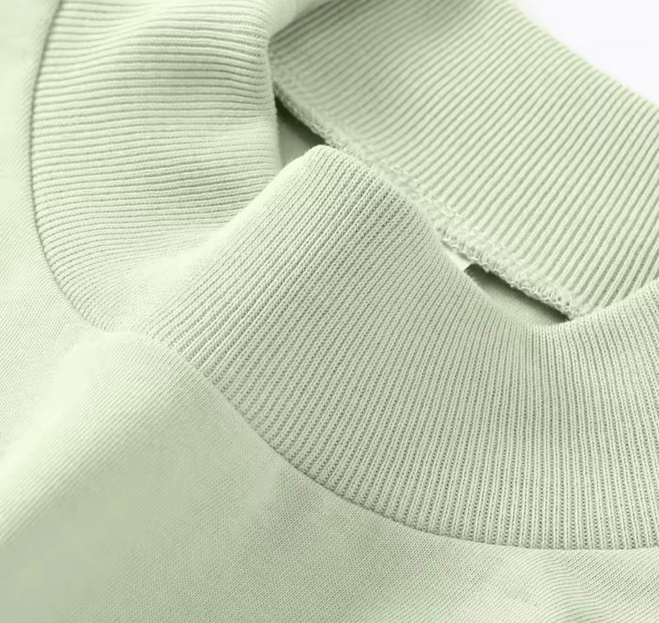 Close-up of sage green mock neck T-shirt collar, emphasizing the ribbed neckline and premium cotton fabric quality.