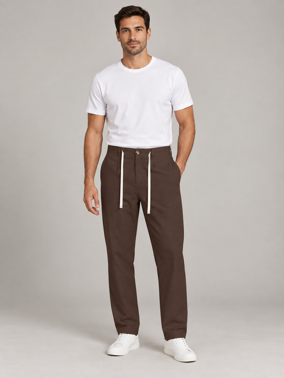 Brown drawstring trousers with a button waist, front view on a model.