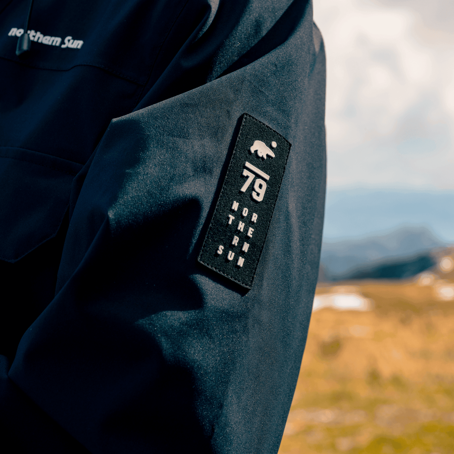 Close-up of Northern Sun 3-in-1 Waterproof Winter Parka sleeve patch with polar bear logo and '79' branding.