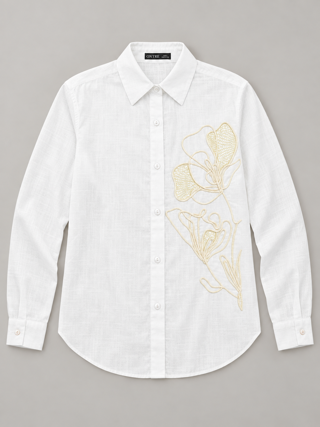 White shirt with pale floral embroidery on the left front, flat lay front.