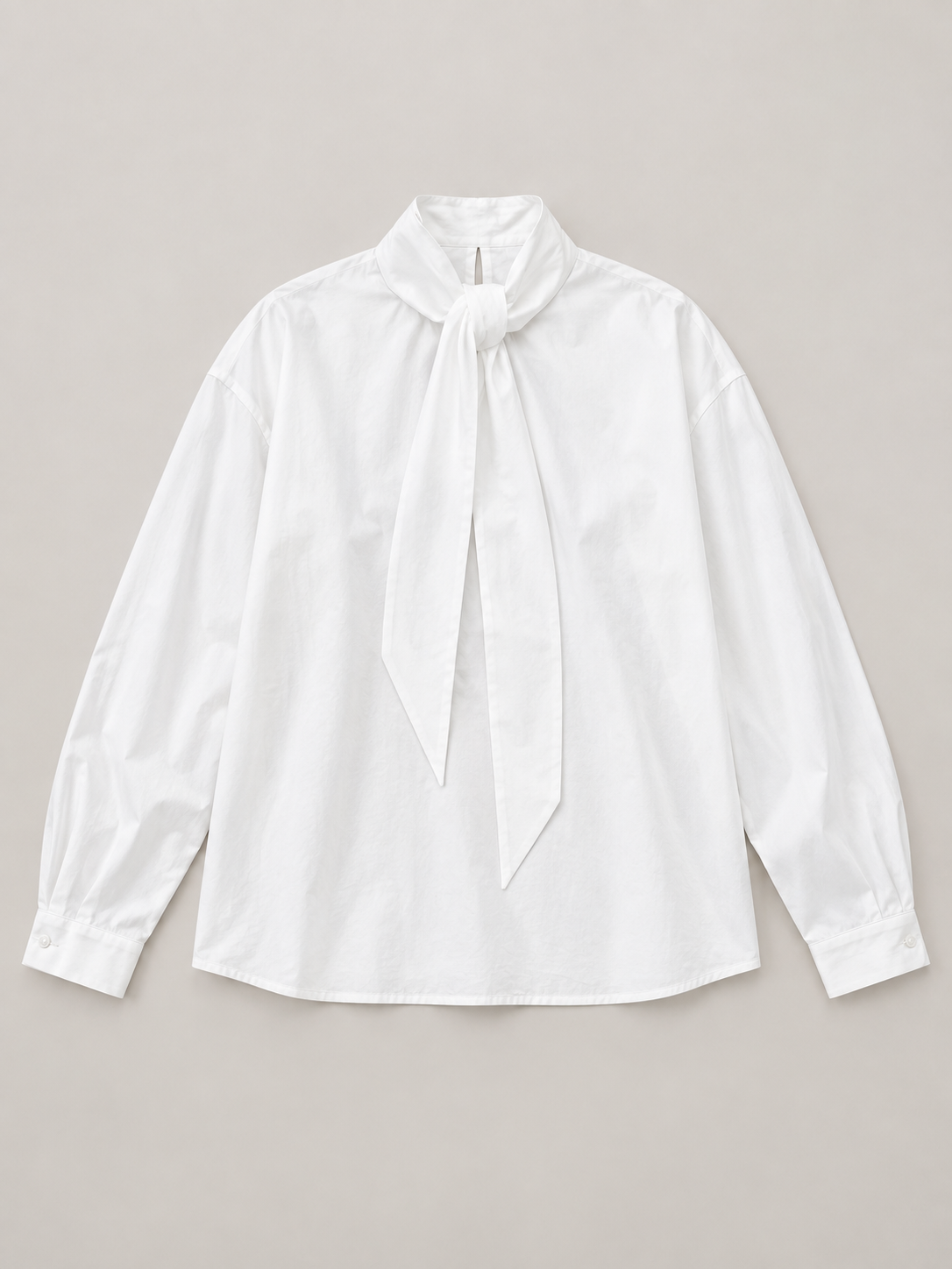 White cotton tie-neck blouse, flat lay front.