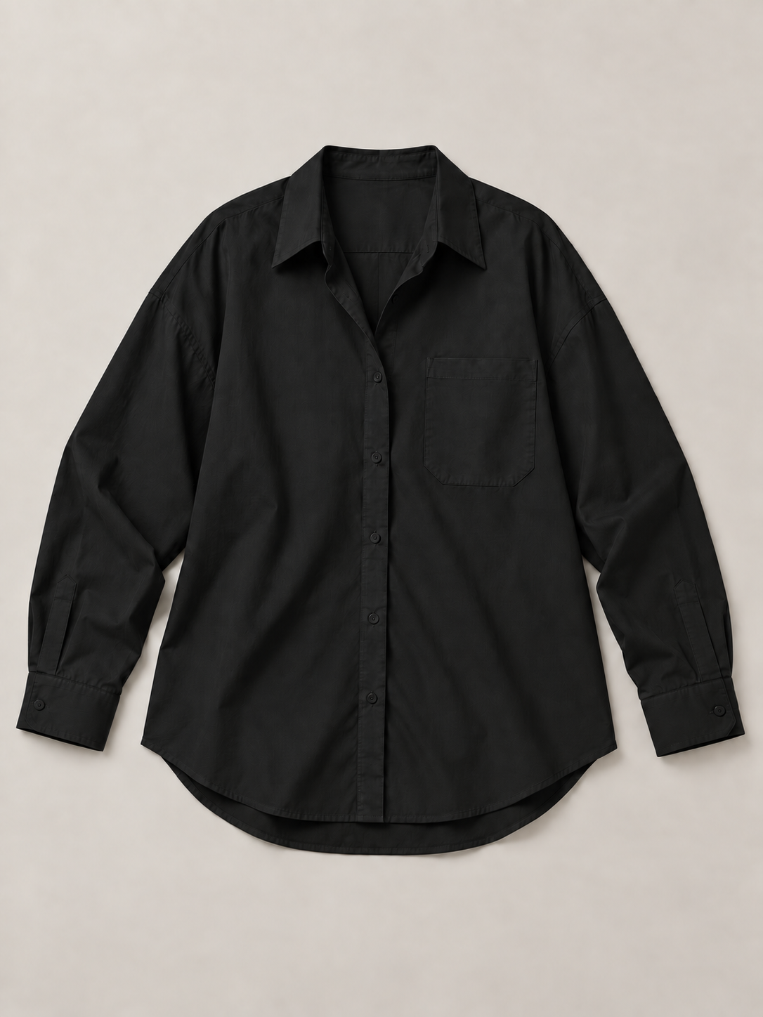 Black oversized button-up shirt, flat front showing the single chest pocket and curved hem.
