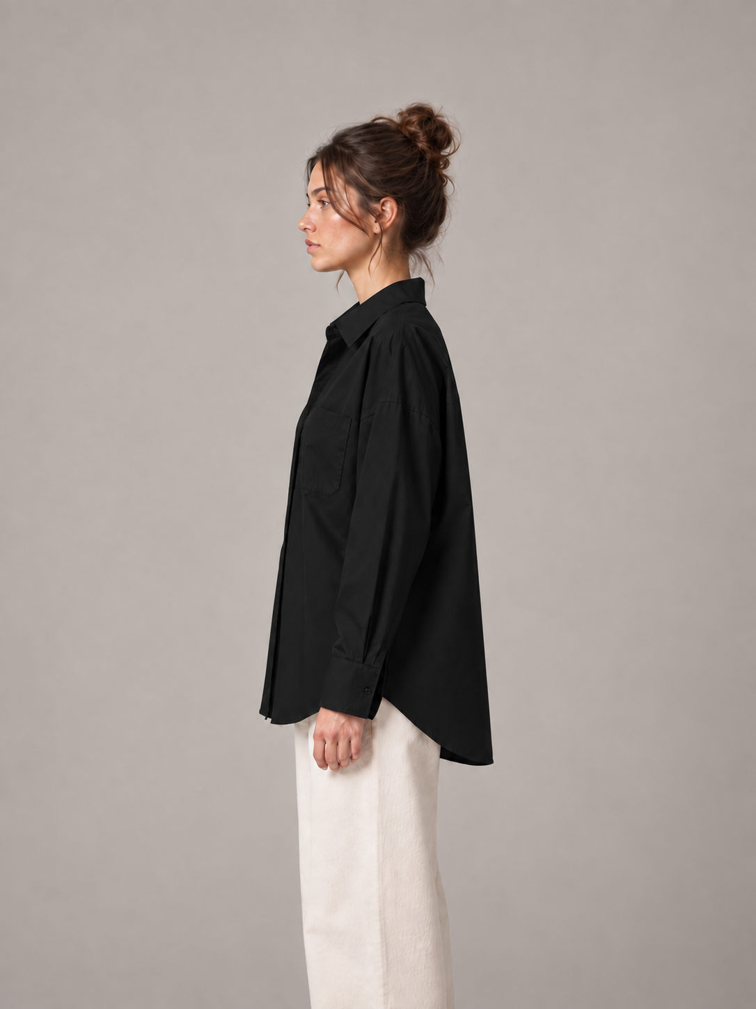 Black oversized button-up shirt, side on an original model showing the longer curved back hem.