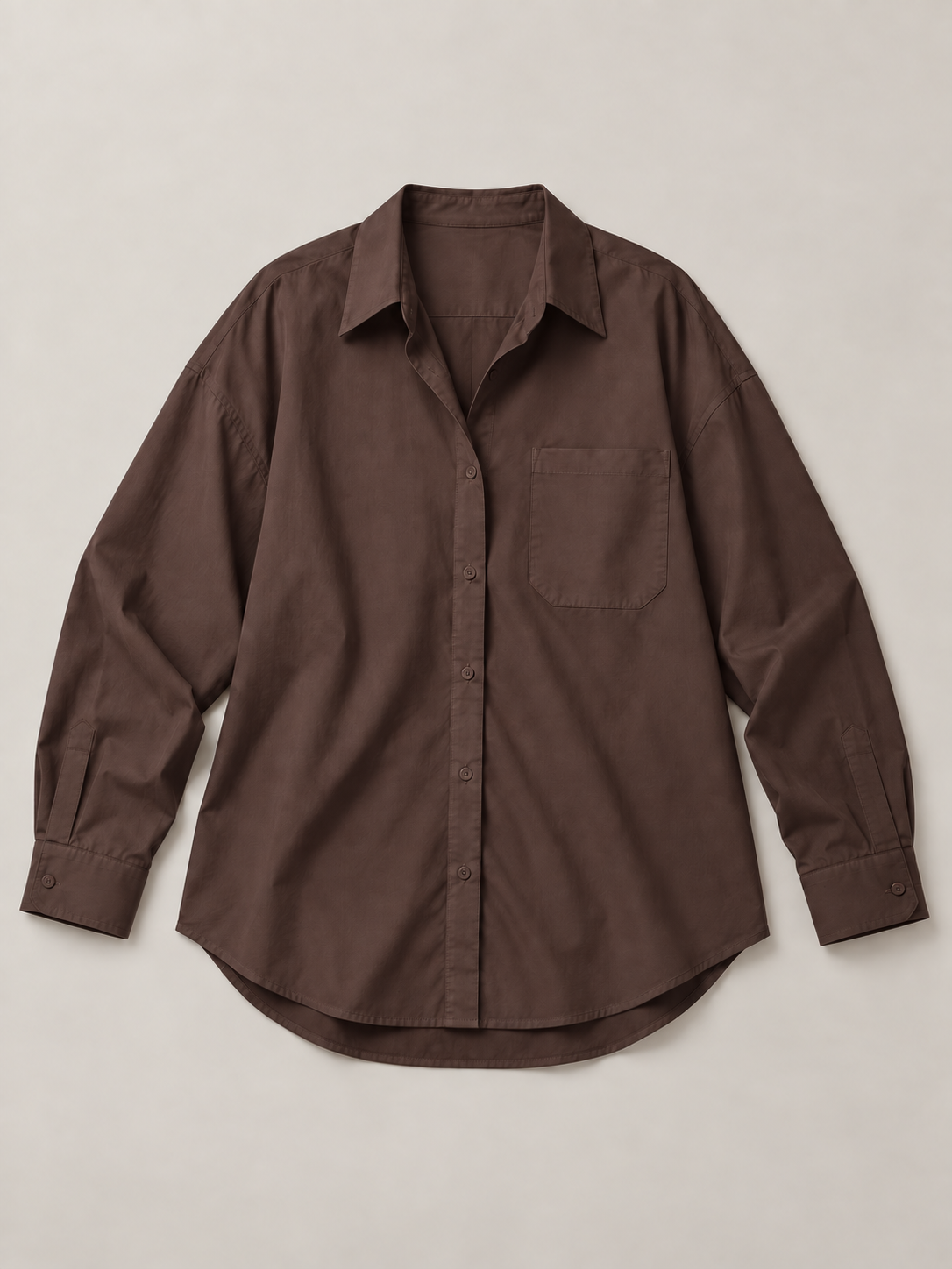 Chocolate brown oversized button-up shirt, flat front showing the single chest pocket and curved hem.
