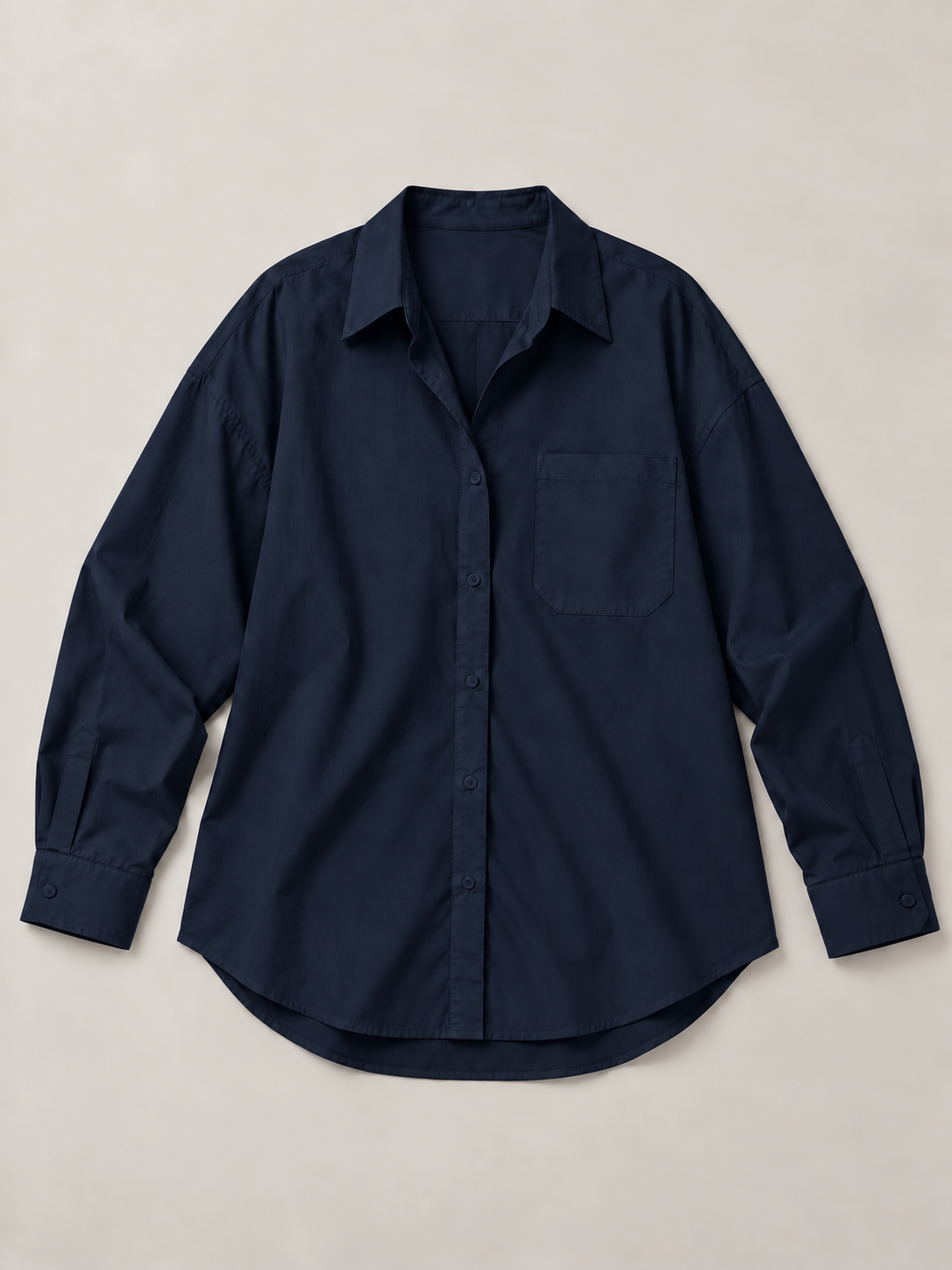 Navy blue oversized button-up shirt, flat front showing the single chest pocket and curved hem.