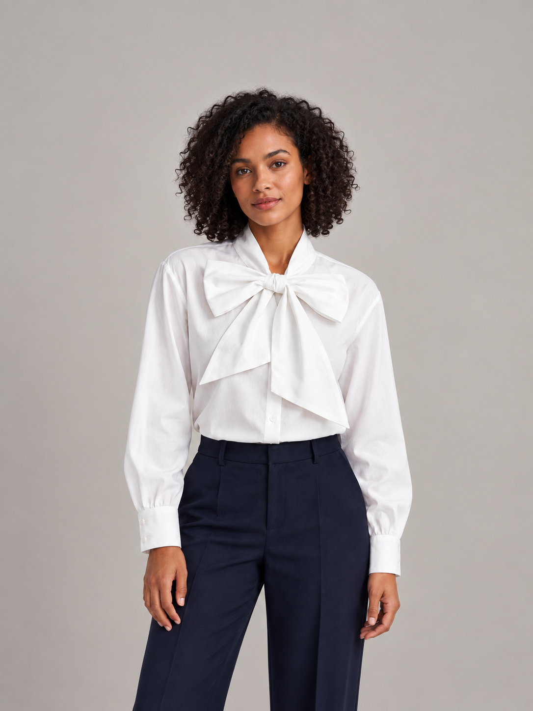 White bow-neck bishop-sleeve shirt, front styling view tucked into trousers.