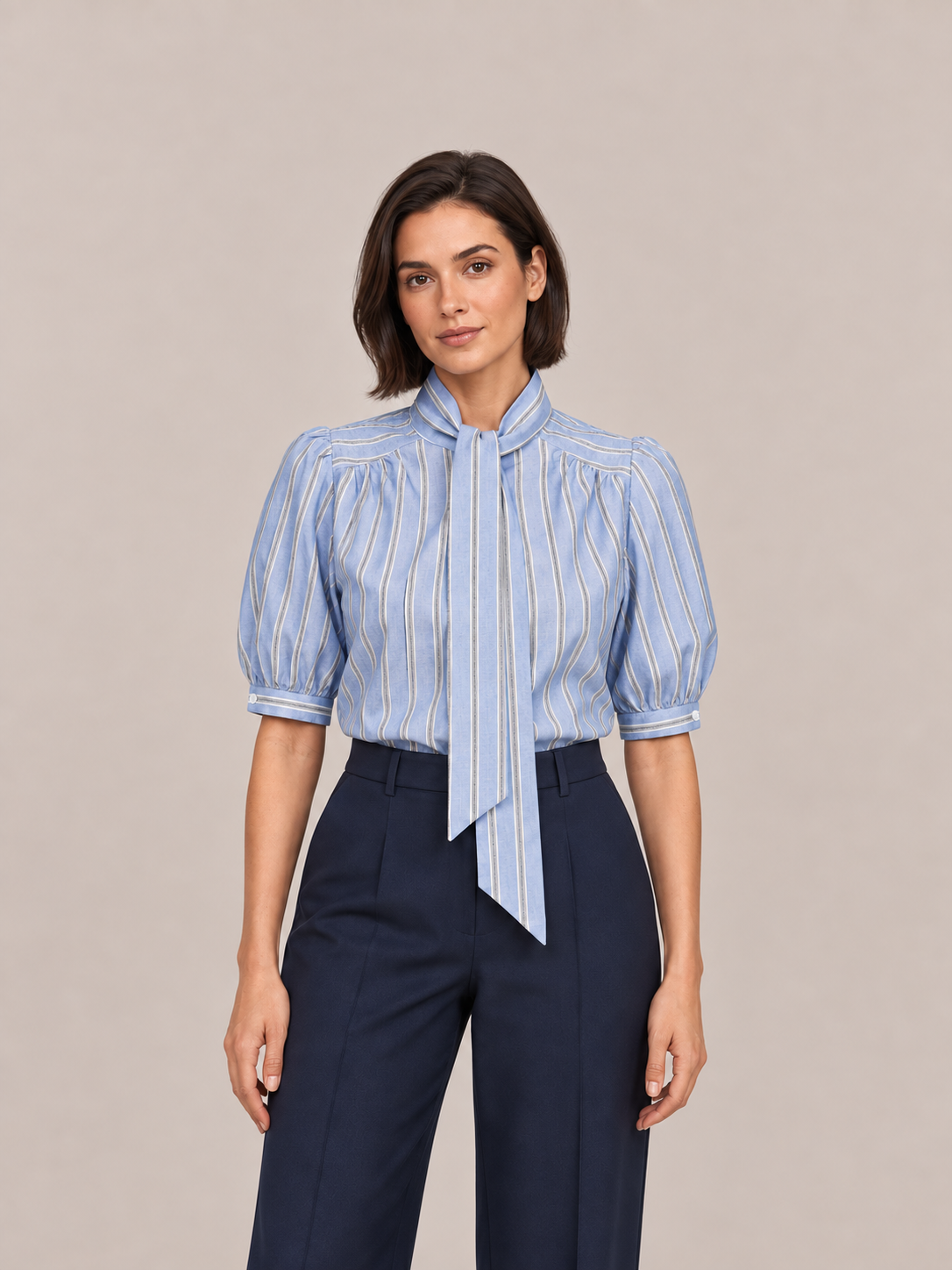 Blue striped tie-neck puff-sleeve blouse, front styling view tucked into navy trousers.