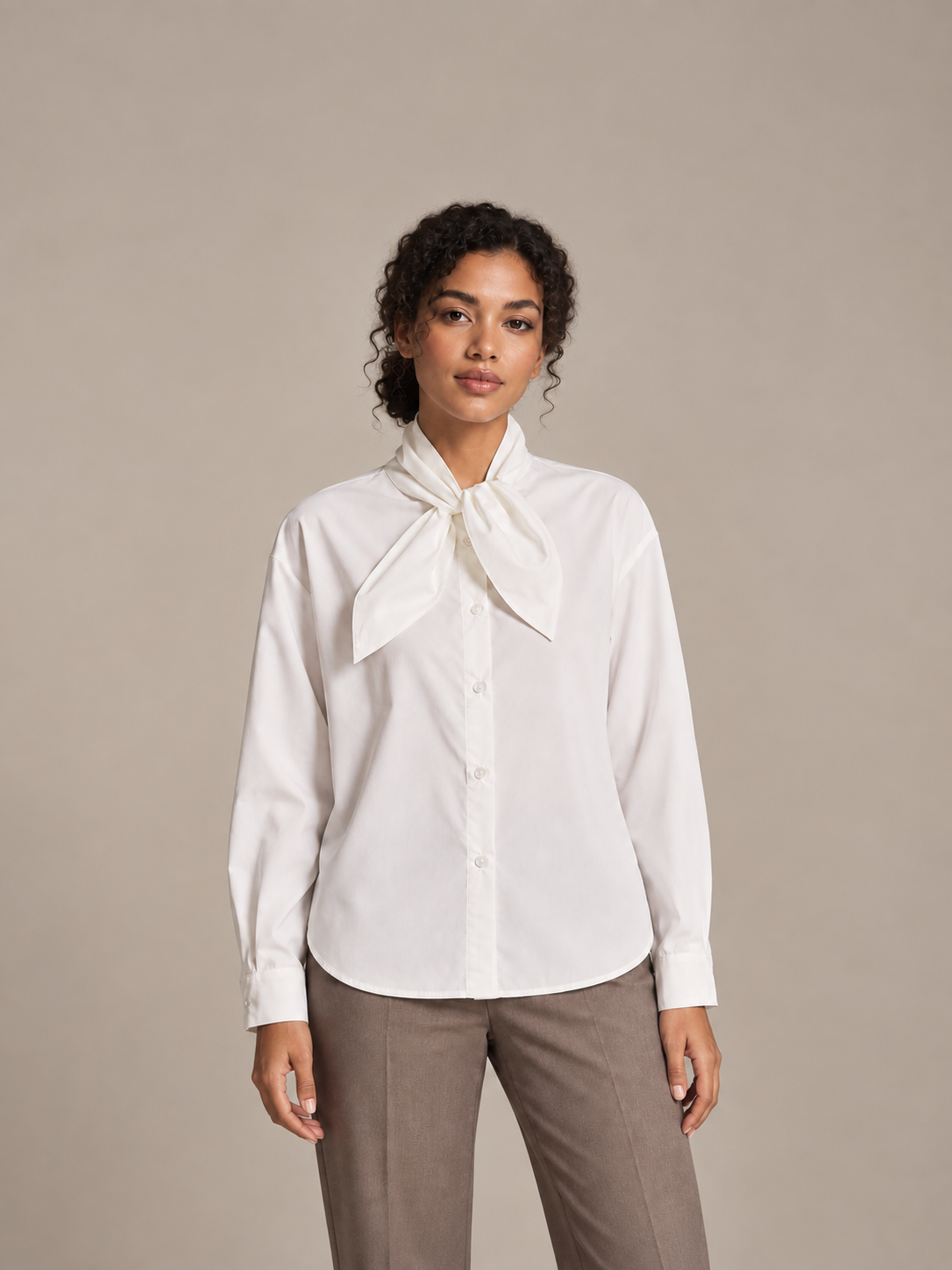 White tie-neck button-front blouse, model front.