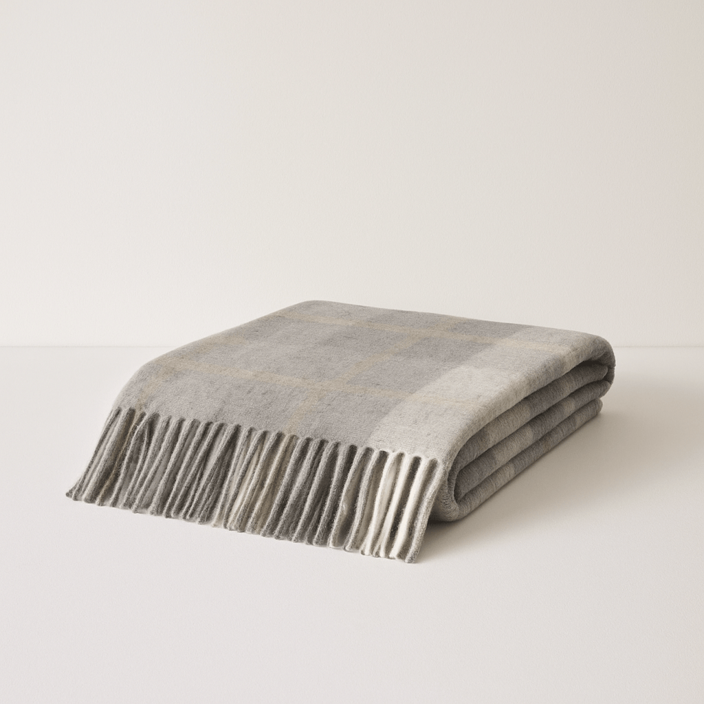 Folded Kawartha Alpaca Blanket in grey plaid pattern showcasing eco-friendly softness and durable warmth for home decor.