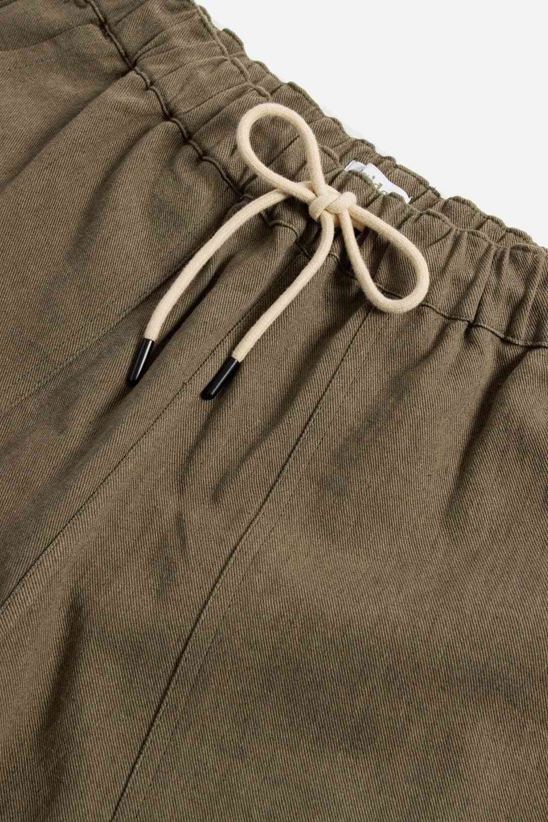 Detailed view of the drawstring and elastic waistband on the olive Palm Springs shorts, emphasizing the linen-cotton blend fabric.