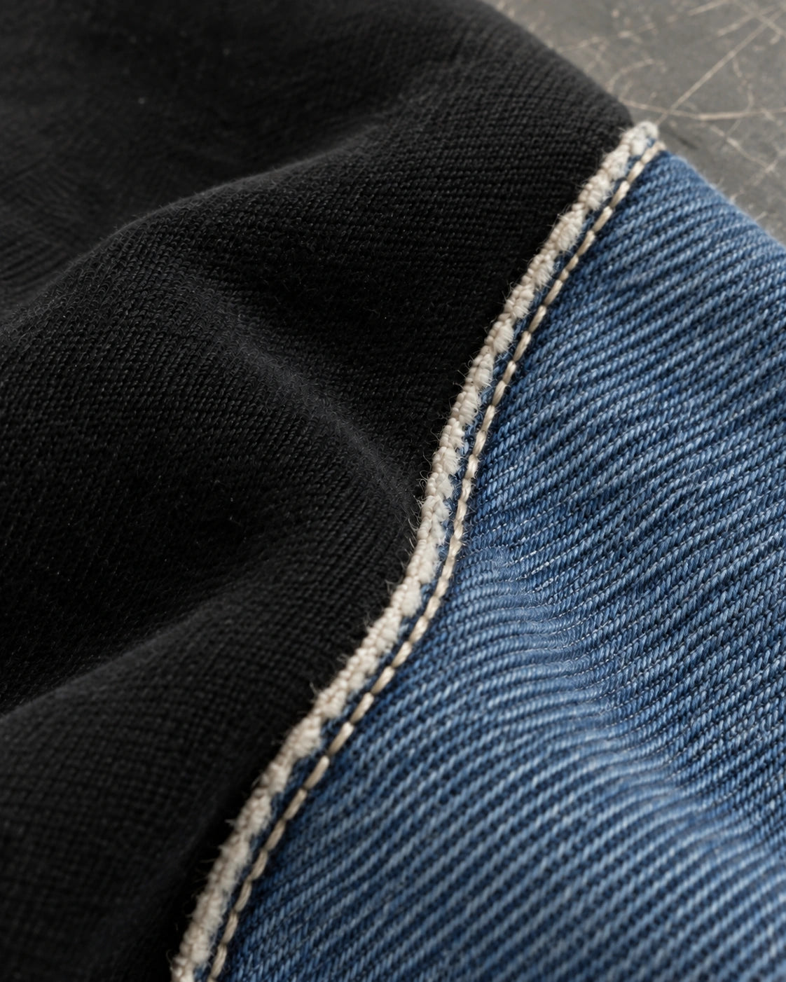 Blue denim and black fabric joined along the Hutton’s fine raw seam edge.
