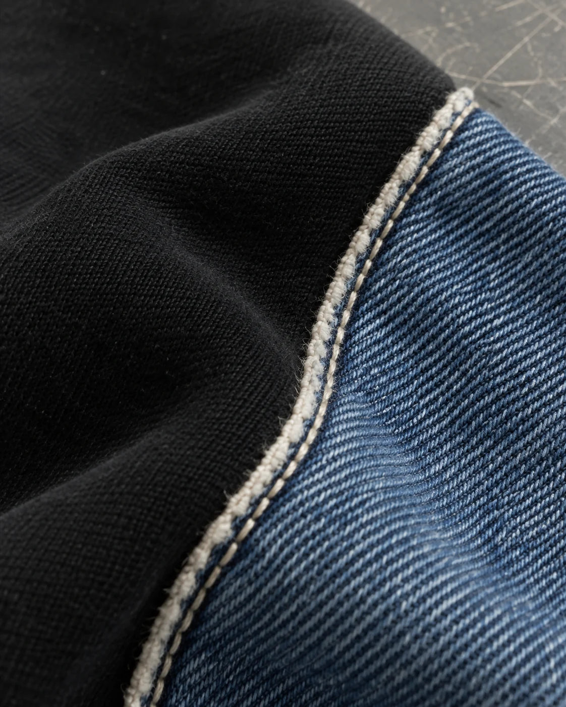 Blue denim and black fabric joined along the Hutton’s fine raw seam edge.