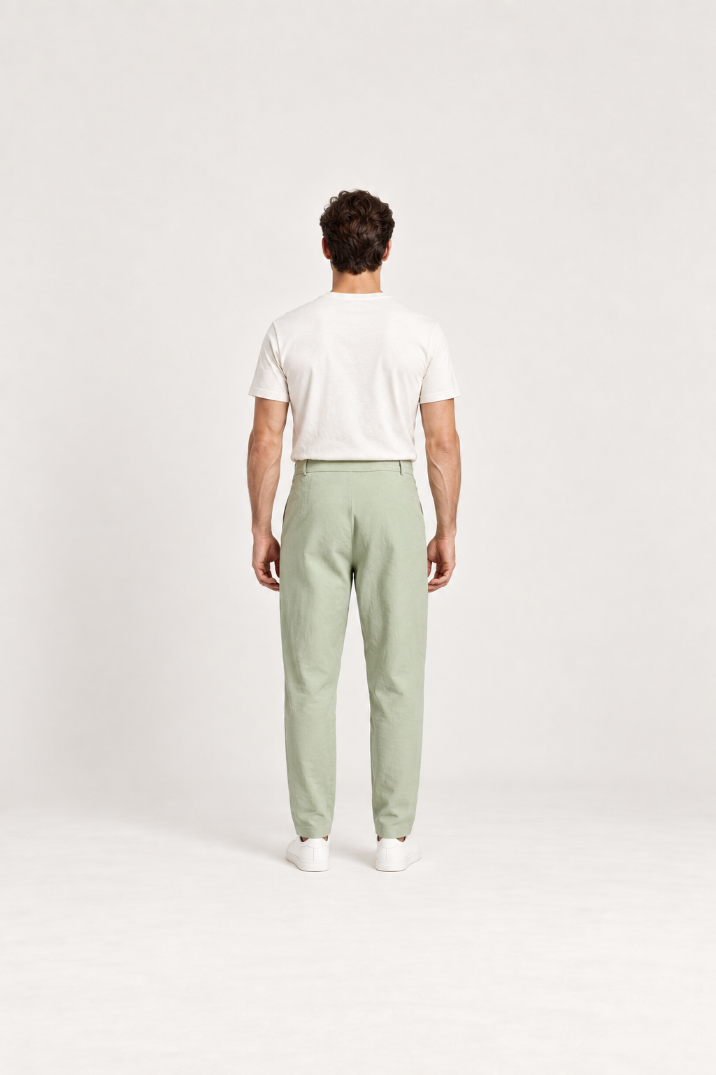 Green cotton pleated drawstring pants, back view on an adult model.