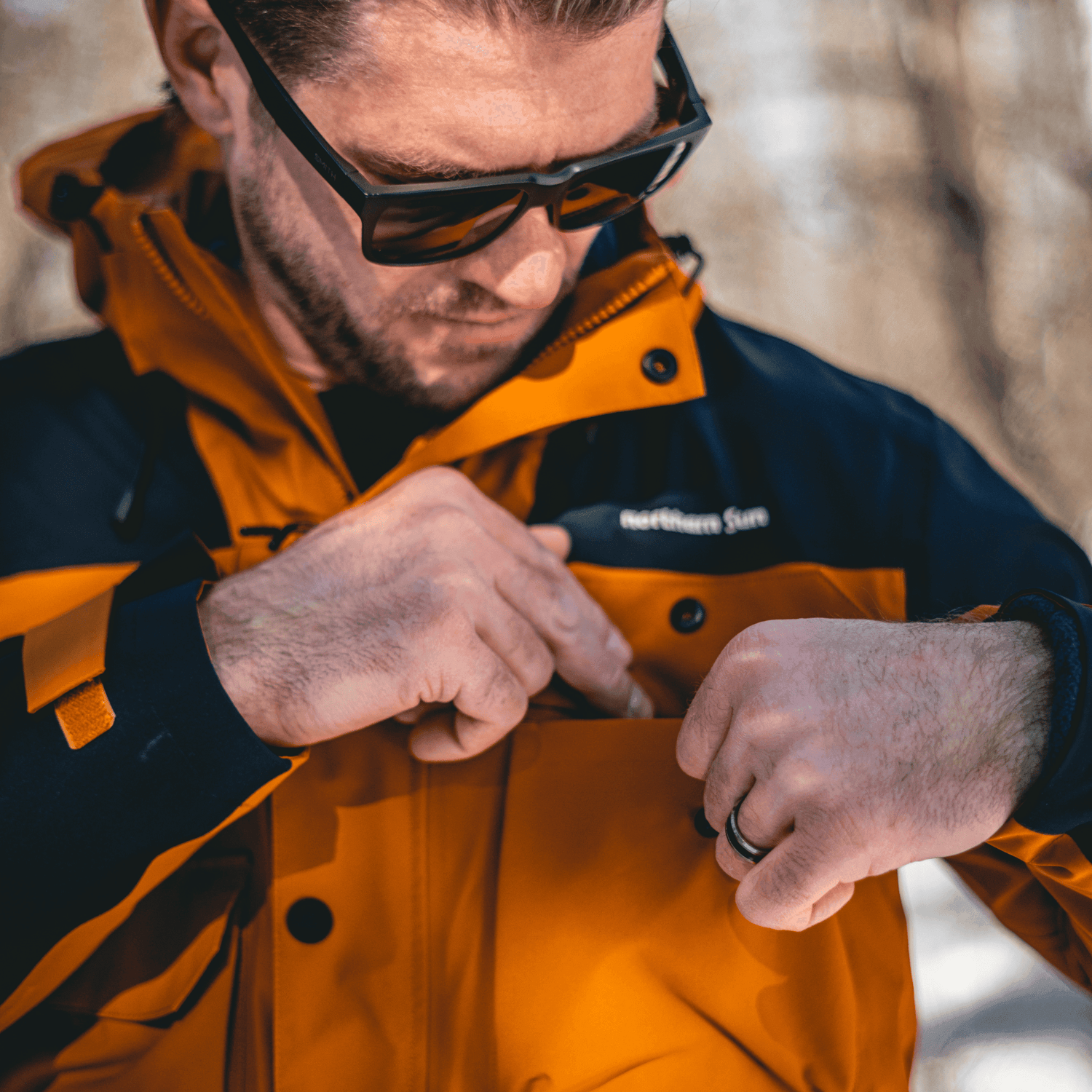Close-up of man using chest pocket on Northern Sun 3-in-1 Waterproof Winter Parka, highlighting functional storage design.