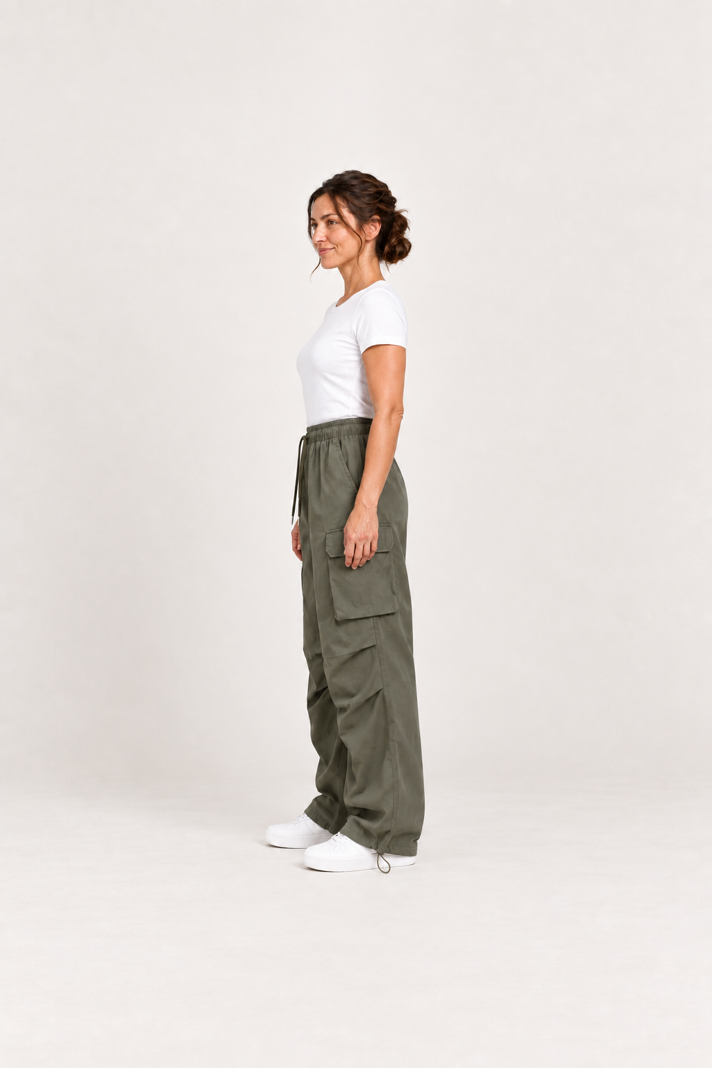 Green cotton cargo pants, model side.
