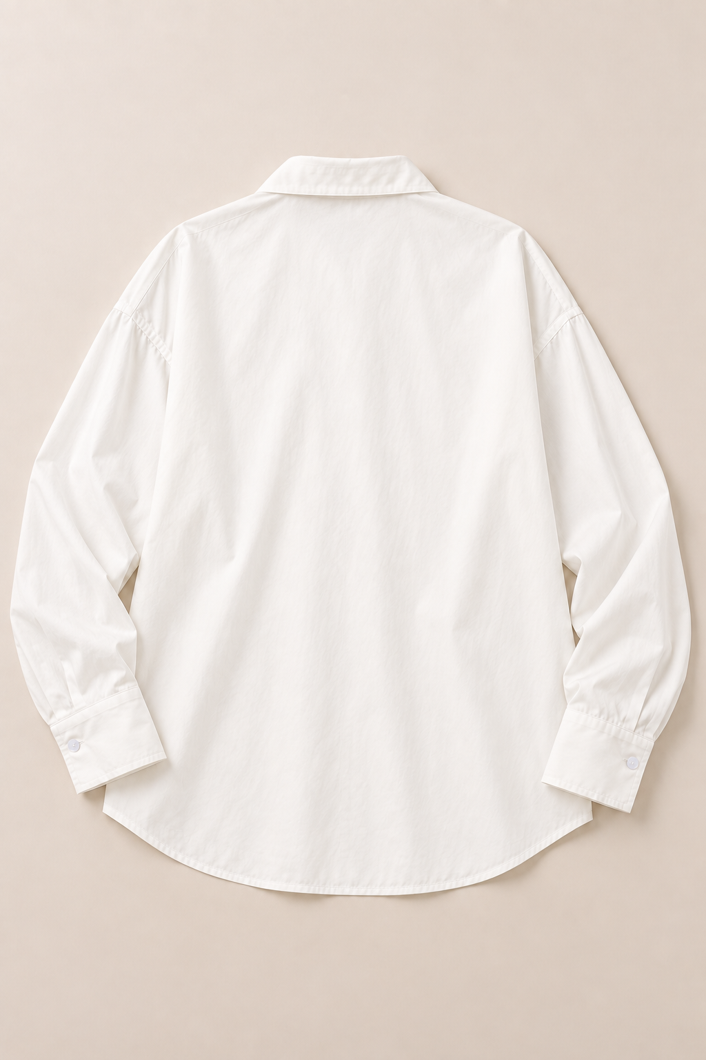Back flat lay of the white cotton shirt with dropped shoulders and curved hem.