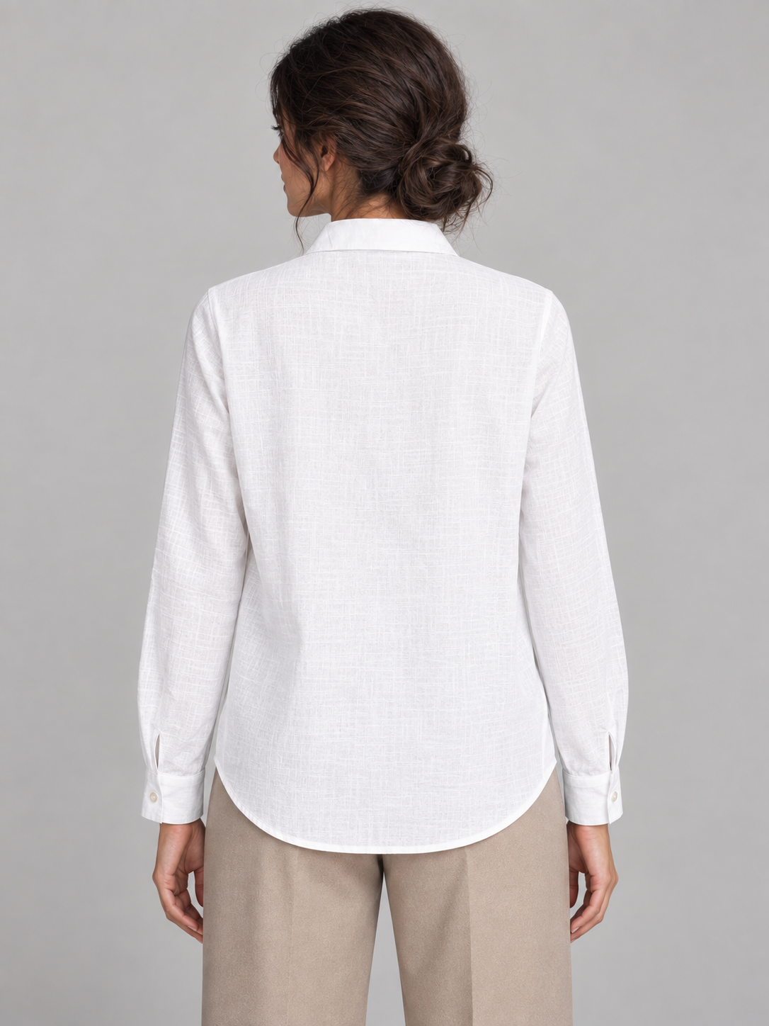 White shirt with pale floral embroidery on the left front, model back.