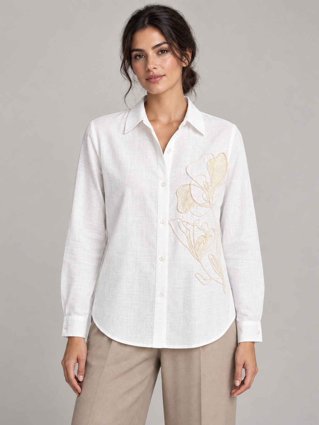 White shirt with pale floral embroidery on the left front, model front.
