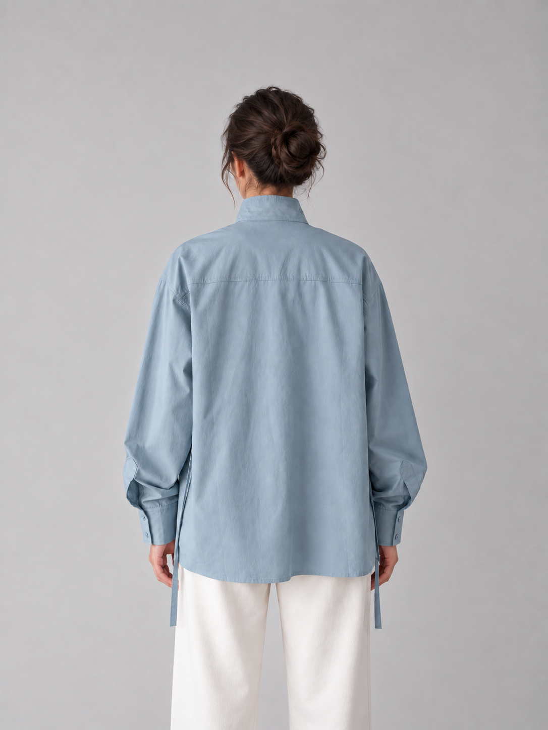 Blue stand-collar tie-waist shirt, model back.