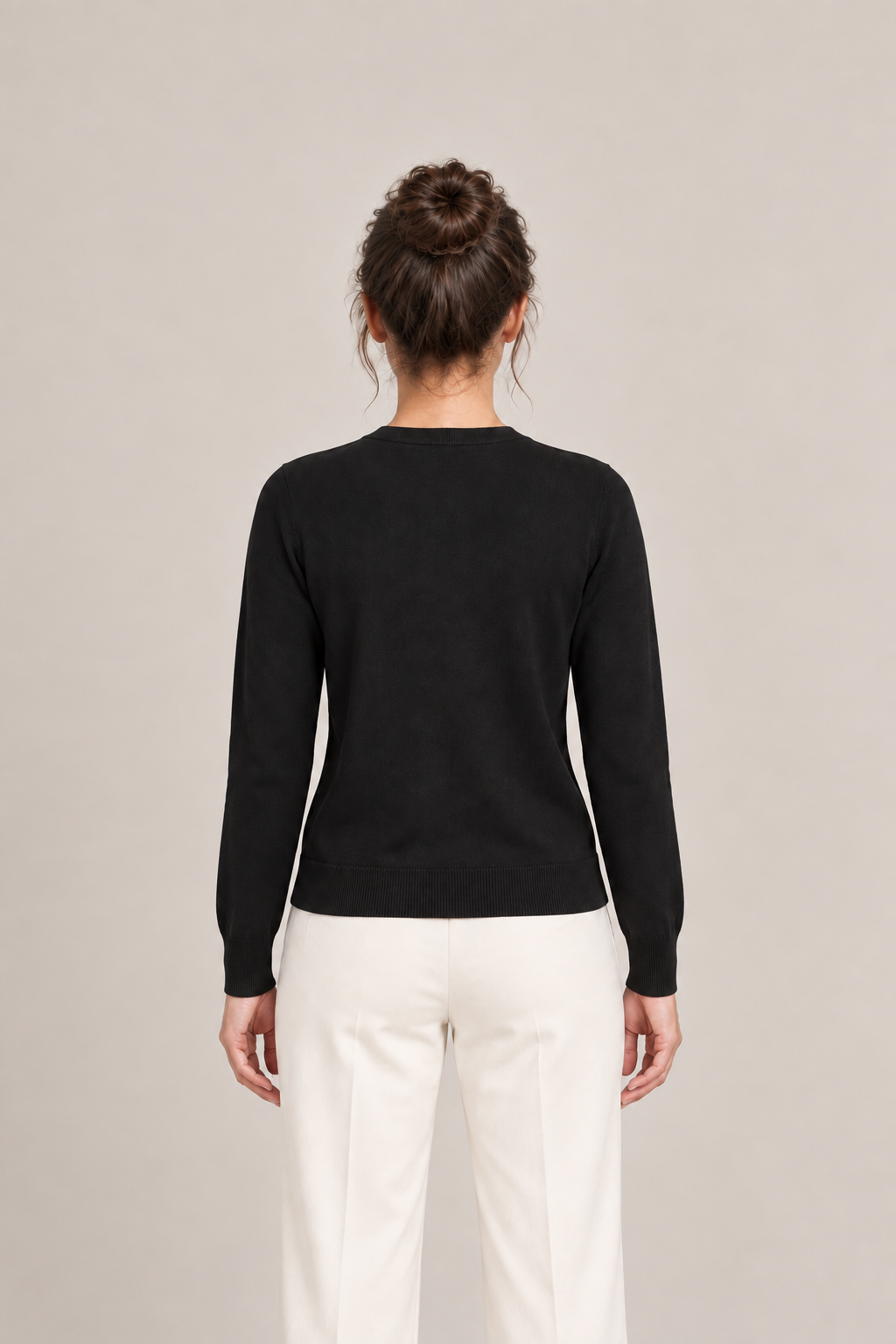 Back view of a black cardigan with long sleeves, ribbed cuffs and a plain back.