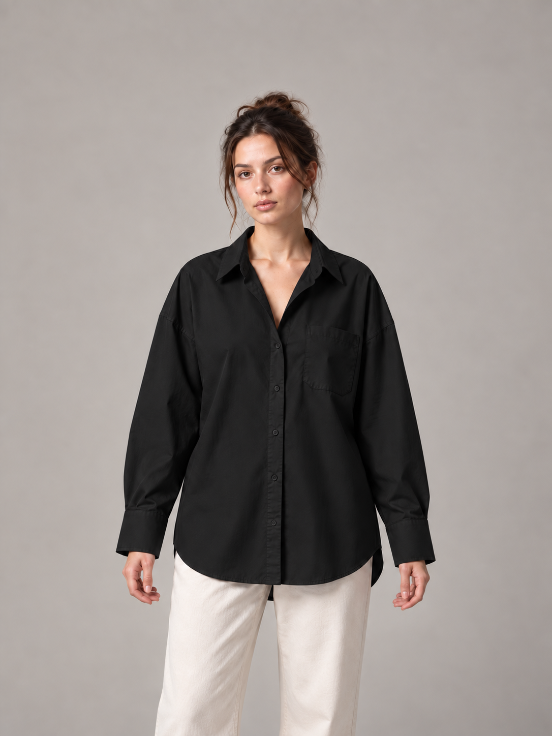 Black oversized button-up shirt, front on an original model with a chest patch pocket.