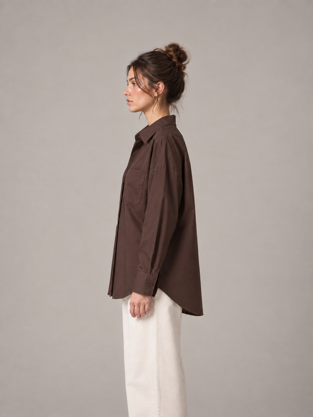 Chocolate brown oversized button-up shirt, side on an original model showing the longer curved back hem.