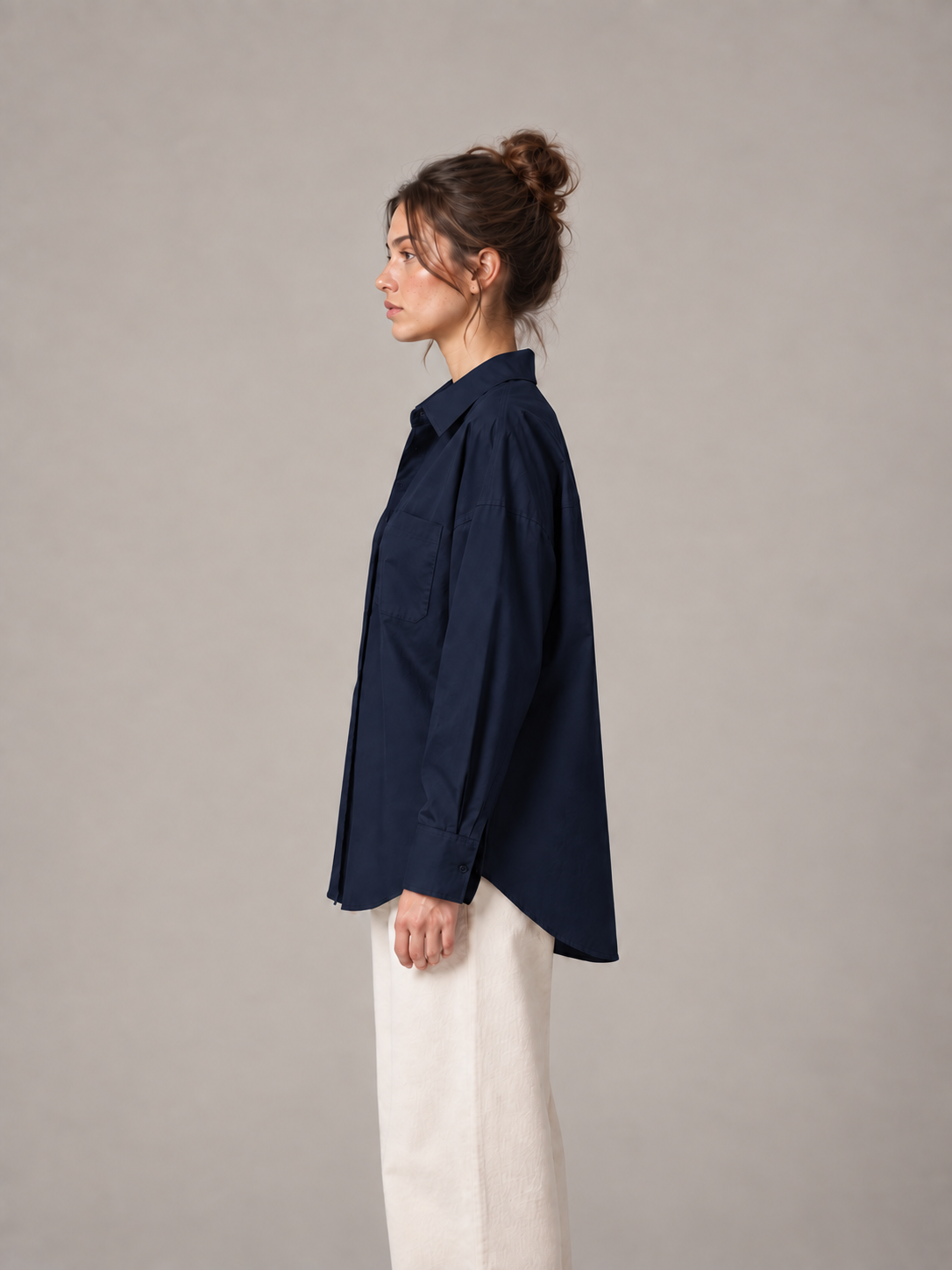 Navy blue oversized button-up shirt, side on an original model showing the longer curved back hem.