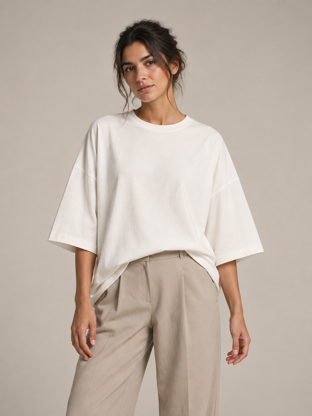 White oversized cotton half-sleeve T-shirt, front styling view tucked into trousers.