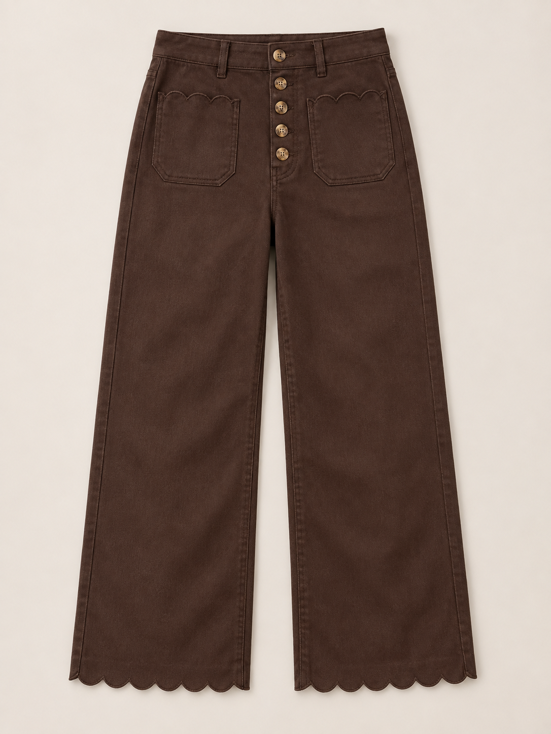 Brown jeans with five front buttons and scalloped pocket edges, flat front view.