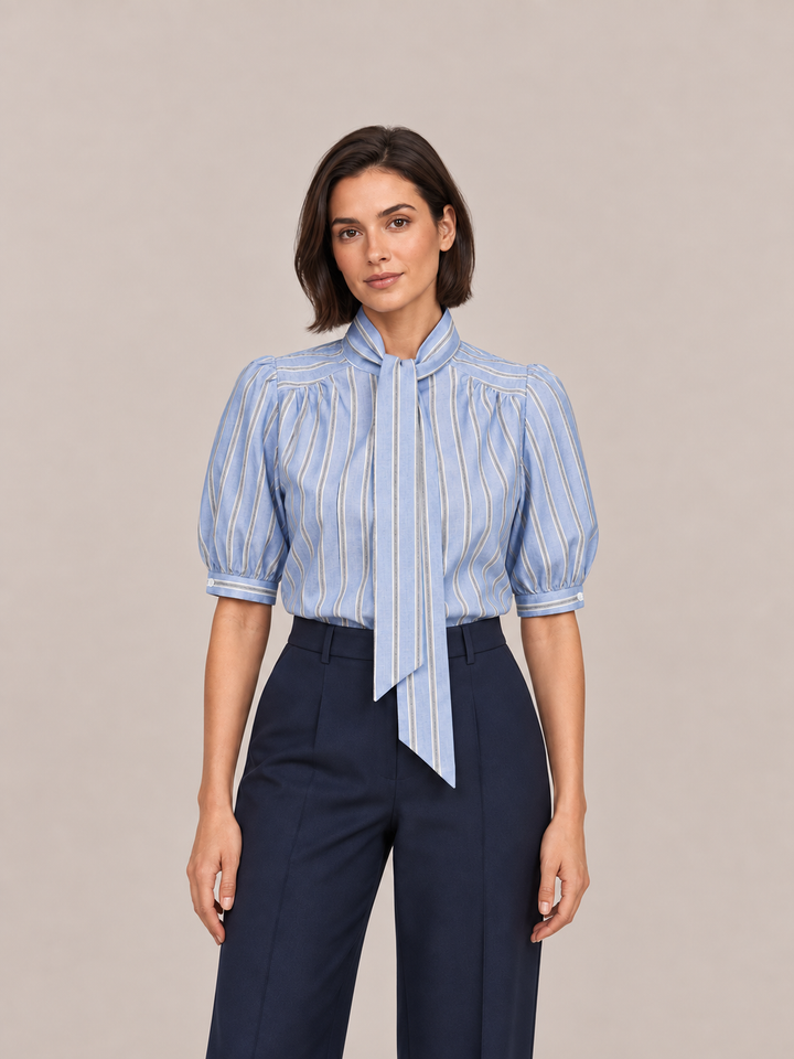 Blue striped tie-neck puff-sleeve blouse, front styling view tucked into navy trousers.