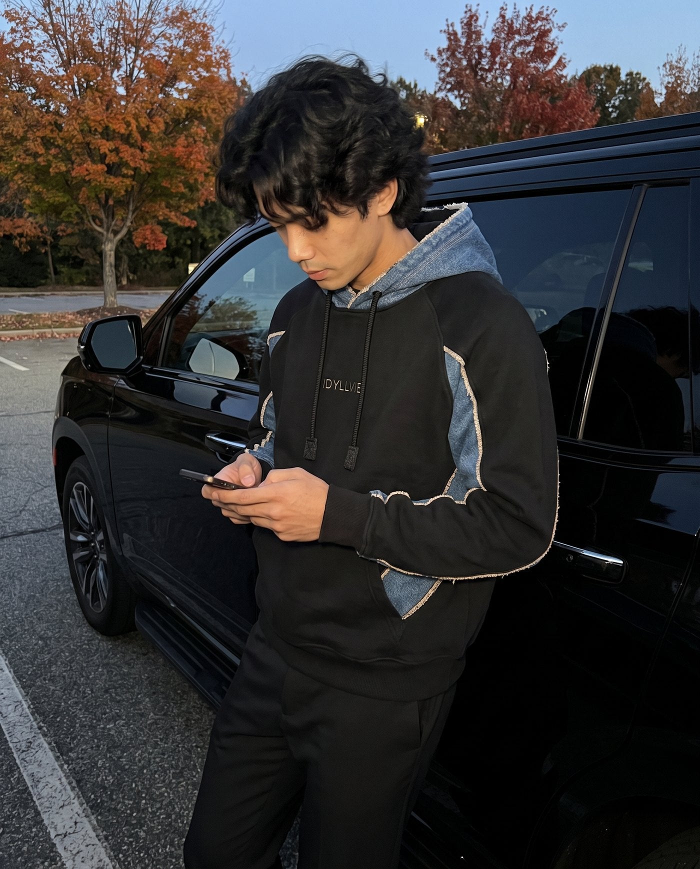 Hutton black denim hoodie in a parking lot